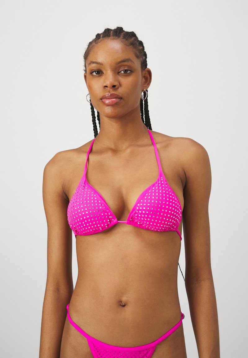 Hot pink triangle bikini top with metallic stud detailing; thin straps and seamless design. Paired with matching minimal coverage bottoms.