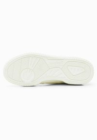 Semelle de sneaker blanche avec un motif texturé, comportant des designs circulaires et triangulaires. Marque et logo visibles sur le côté latéral.