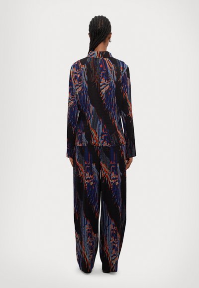 Nyomtatott két részes szett, hosszú ujjú felsővel és bő szárú nadrággal. Az anyag texturált felületű, élénk kék, piros és fekete mintázattal.