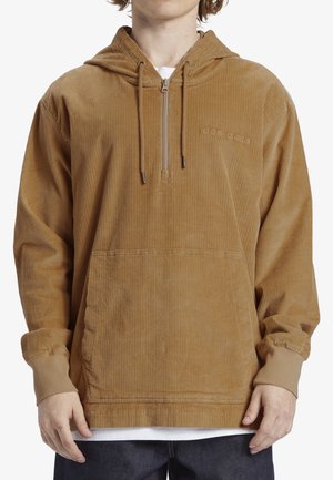 Sudadera con capucha de pana marrón, con un bolsillo frontal, cierre de media cremallera y capucha con cordón. Puños de canalé y detalle de tela texturizada.