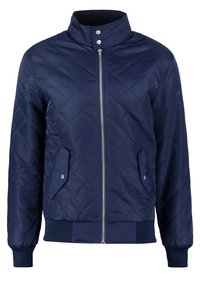 Tummansininen tikattu takki, jossa on korkea kaulus, etuvetoketju, painonappilistalla varustetut taskut ja resorit hihansuissa ja helmassa.