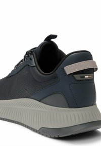 Sneaker blu navy con tomaia in mesh testurizzato, dettagli tonali e una suola spessa grigio chiaro con scanalature e marchio sul tallone.