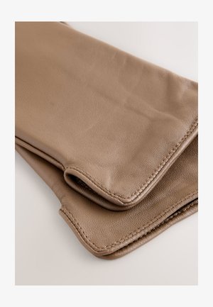 Šviesiai rudos odos piniginė su lygiu paviršiumi, lankstoma konstrukcija ir matomomis siūlėmis. Turi apvalintus kampus ir minkštus akcentus.