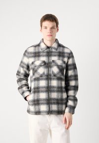 Gray and white checkered flannel jacket with a zip closure, two chest pockets, and a collar. Features a soft, textured fabric.