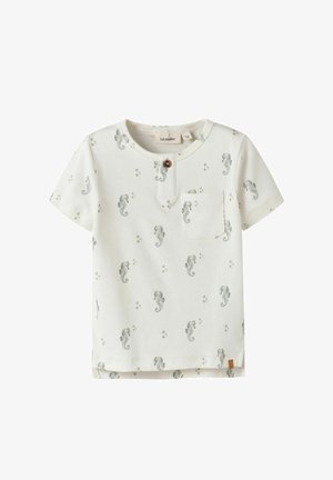 Camiseta blanca de manga corta para niño pequeño con patrón de caballito de mar gris, pequeño bolsillo en el pecho y un botón marrón en el cuello redondo.