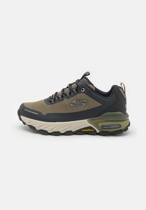 Scarpa da trekking impermeabile in verde scuro e blu navy, con tomaia in rete, suola in gomma e ammortizzazione prominente. Presenta il logo del marchio e i lacci.