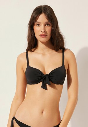 Schwarzer Bikini-Oberteil mit einer Bindefrontgestaltung, weichem Stoff und dünnen verstellbaren Trägern. Glatte Textur und nahtlose Verarbeitung.