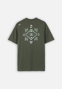 Camiseta de algodón verde oliva con un gran diseño floral en blanco y azul claro y el logo de la marca en la parte posterior, con un corte relajado y mangas cortas.
