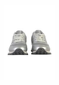 Scarpe da ginnastica argento con finitura lucida, dotate di lacci bianchi, una suola intermedia texturizzata e una suola esterna con motivo a zigzag.