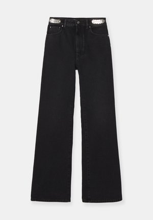 Jean large noir présentant une taille haute, un design classique à cinq poches et des accents métalliques sur la ceinture. Fabriqué en tissu en denim.