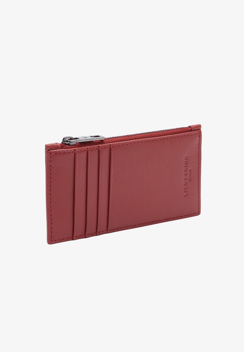 Portefeuille en cuir rouge au design épuré, doté d'une fermeture éclair et de quatre emplacements pour cartes d'un côté. Texture lisse, branding minimal.