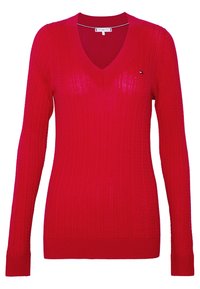 Pull rouge en tricot avec manches longues, col en V, texture côtelée et petit logo accentué sur le côté gauche.
