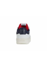K-Swiss white sneaker with navy leather accents, red lining, padded collar, and textured sole. Features branding on heel and tongue.