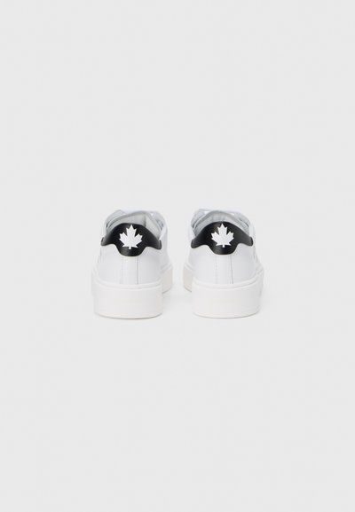 Baskets blanches avec une tige en cuir lisse, une languette en tissu gris et des accents noirs au talon ornés d'un logo feuille d'érable blanc.