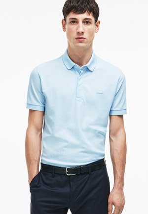 Polo shirt azzurro chiaro con maniche corte, tessuto strutturato e colletto con bottoni; presenta un piccolo logo ricamato sul petto.