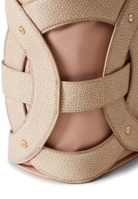 Beige textured leather bag featuring a smooth, curved design with layered straps and a gold accent. Interior is a soft neutral fabric.