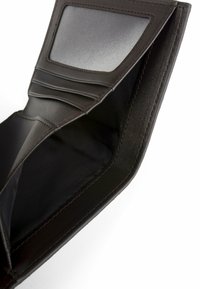 Interno di portafoglio in pelle marrone con scomparti per carte, finestra trasparente per documento d'identità e finitura testurizzata con cuciture visibili.