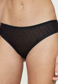 Czarne koronkowe bikini z teksturowanym wzorem, elastycznym pasem i gładkimi krawędziami w minimalistycznym stylu.