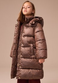 Manteau matelassé marron avec capuche, présentant un design matelassé, une texture brillante et une fermeture éclair dorée à l'avant avec boutons-pression.