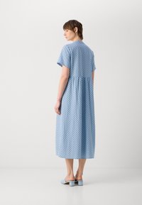 Abito blu a pois con maniche corte, una vita arricciata e lunghezza midi. Realizzato in tessuto leggero con una texture liscia.