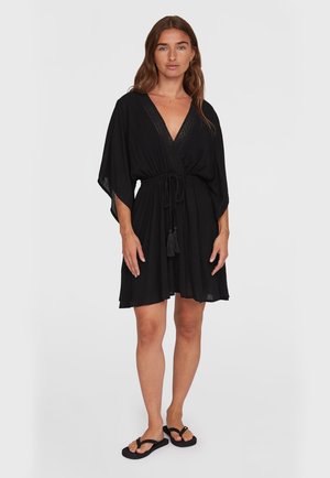 Svart kaftan klänning med V-hals, kvastband i midjan och öppna ärmar. Tyget är lätt och har en mjuk textur.