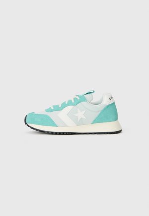 Lyseblå og hvide lave sneakers med hvid stjerne-logo, snørelukning, ruskindsaccents og sort slidbane på grå baggrund.
