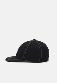 Black cap with a curved brim, featuring contrasting yellow stitching and a small logo on the side. Smooth cotton material, fitted design.