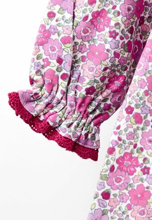 Ärmelbündchen aus pink- und lila-musterndem Stoff mit elastischen Rüschen und dunkelrosa Häkelspitzenabschluss.
