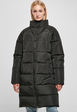 Manteau rembourré noir avec un col haut, doté de sections matelassées horizontales, de poches latérales et d'une fermeture éclair sur toute la longueur. Tissu lisse et brillant.