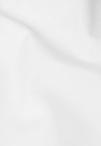 Bela tkanina z nežnimi gubami in subtilnimi sencami, ki ustvarjajo gladko, mehko teksturo.