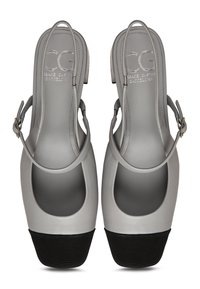 Scarpe slingback in pelle grigia con punta aperta e accento in gomma nera sul tacco, caratterizzate da un design curvo e cinturino alla caviglia regolabile.