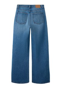 Traperice širokih nogavica u srednje plavoj boji. Imaju dva stražnja džepa i zakrpu na pojasu. Materijal ima blago istrošenu teksturu.