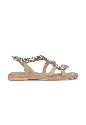 Sandalias planas beige con un acabado en ante texturizado, que cuentan con una correa decorativa adornada con piedras preciosas multicolores y acentos metálicos.