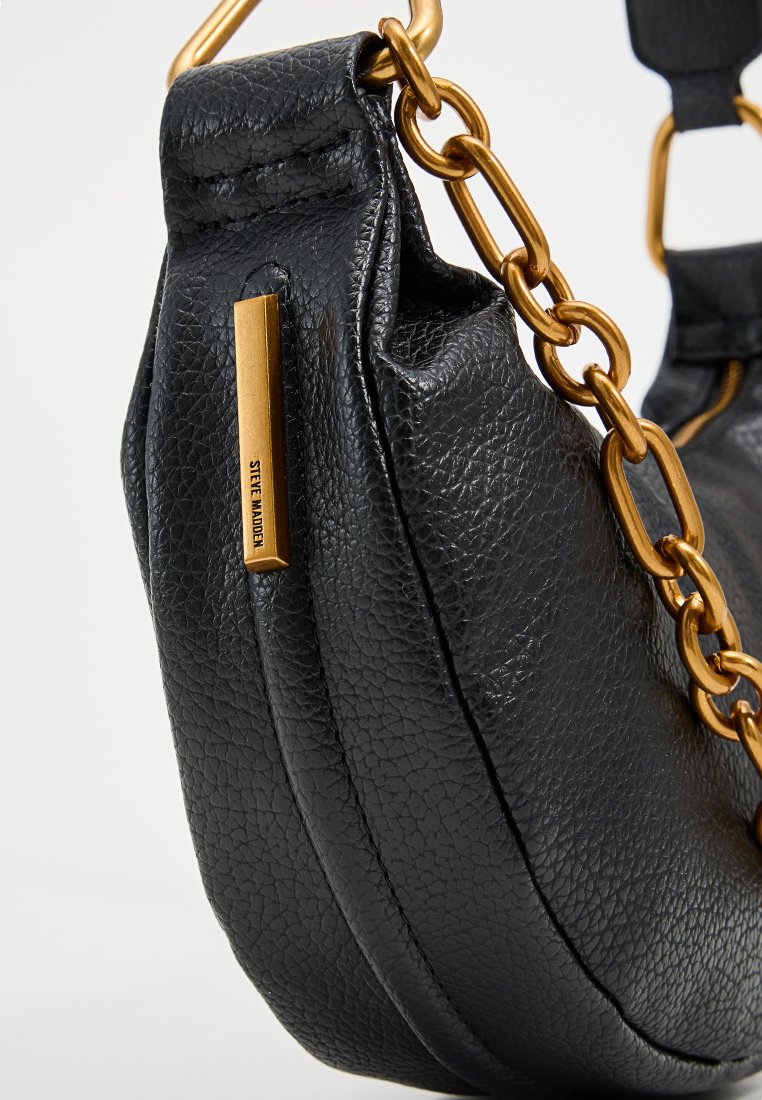 Bolso de mano de cuero negro con acabado texturizado, asa de cadena dorada y un acento del logotipo en dorado. Forma redondeada con un diseño suave y caída.