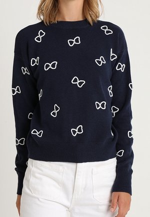 Maglione a maglia navy con motivi a fiocco bianchi, scollatura rotonda, polsini e orlo a costine. Texture morbida, vestibilità rilassata, adatto per un abbigliamento casual.