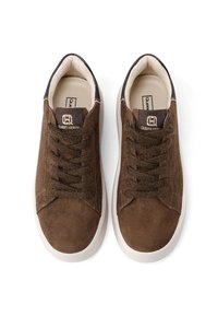 Un paio di sneakers in suede marrone con suole bianche e lacci marroni, viste dall'alto, con il logo "Queen Helene" sulla linguetta.