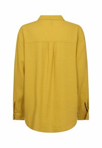 Senfgelbes Hemd mit Kragen, langen Ärmeln und einer Rückenfalte. Hergestellt aus strukturiertem Stoff, mit geknöpften Manschetten.