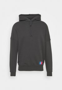 Felpa con cappuccio grigia scura con coulisse, tasca a marsupio e polsini elasticizzati. Presenta una toppa con logo multicolore sul lato inferiore.