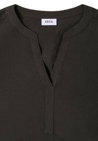 Dunkelgrüne Bluse mit V-Ausschnitt, kurzen Ärmeln und glatter Textur. Mit einem Etikett "CECIL" am hinteren Halsausschnitt.