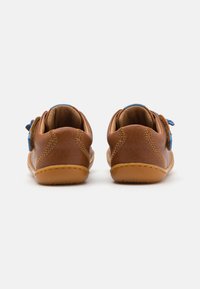 Chaussures en cuir marron avec des accents bleus, dotées d'une semelle flexible et de coutures contrastées. La vue arrière révèle un talon texturé et une finition lisse.