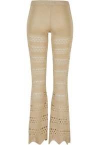 Pantalon évasé en maille beige avec des rayures en ajouré à motifs et un ourlet festonné, doté d'une ceinture élastique.