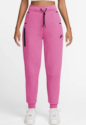 Pink sweatpants with a drawstring waist, side pockets, and black accents. Made of soft fabric with tapered legs and ribbed cuffs. Nike logo displayed.