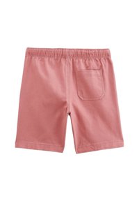 Shorts en coton rose avec une taille élastique, une poche arrière à patte unique et une coupe décontractée, présentant une texture lisse et douce.