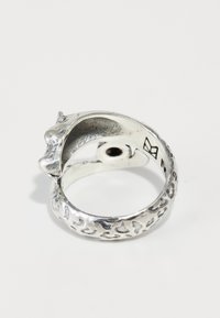 Bague en argent ayant une forme organique et torsadée, avec une surface texturée et une petite tête d'animal stylisée à une extrémité.
