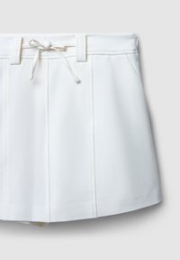 Weiße Shorts mit Kordelzugbund, flache Vorderseite und zwei seitlichen Falten. Der Stoff wirkt glatt mit einem leichten Glanz.