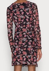 Blomstret kjole med lange ærmer i gennemsigtig stof, med en sort baggrund og blomster mønstre i pink, burgunder og grå. Rundet halsudskæring.