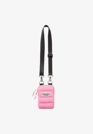 Pink padded crossbody bag featuring a black strap, zip closure, and a label patch with text. Smooth texture, rectangular shape, and minimal design.