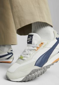 Weiß und marineblauer Sneaker mit grauer Gummisohle, Obermaterial aus Wildleder und Mesh, Akzente in Orange und Limette sowie gepolsterter Zunge mit Logo-Patch.