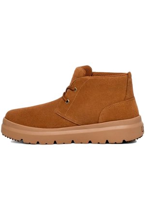 Stivaletti alla caviglia in suede marrone con punta arrotondada, design con lacci e suola in gomma caratterizzata da un motivo testurizzato per una presa ottimale.