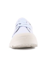 Απαλή μπλε καμβάς αθλητικά παπούτσια με λευκή καουτσούκ σόλα, στρογγυλή μύτη, σχέδιο με κορδόνια και λογότυπο στη γλώσσα. Λείος υφή και ελάχιστες λεπτομέρειες.